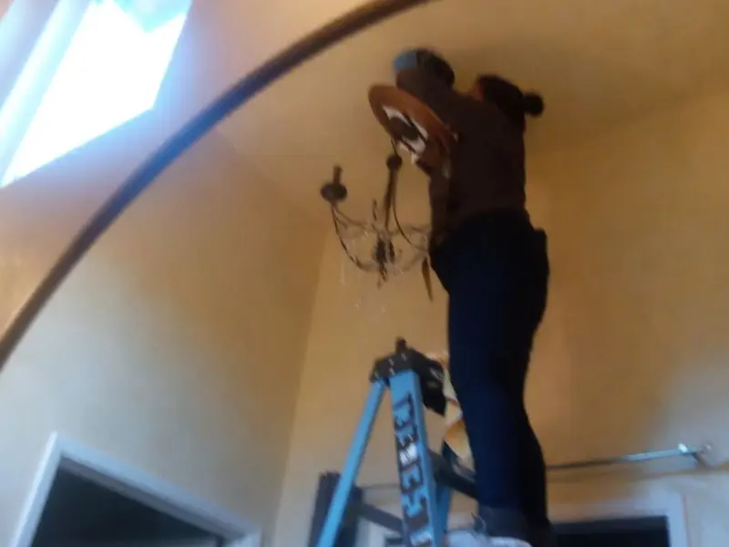 Electrician installing a chandelier in a Plumas Lake residence